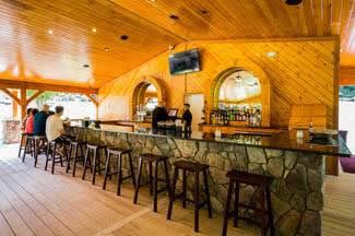 Holidays & Catering 19 Pavilion bar with wood siding and stone table