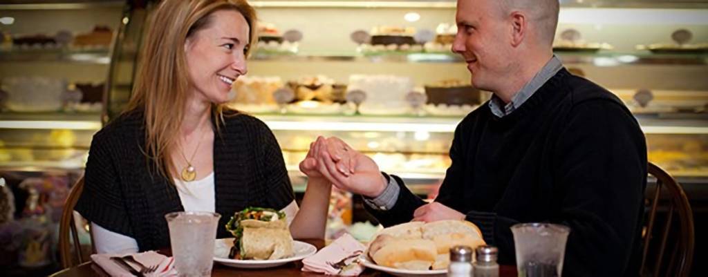 Couple holding hands while eating lunch