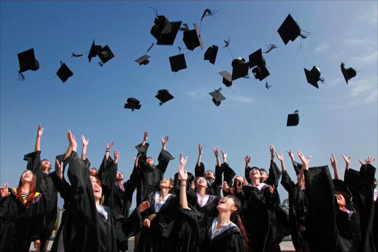 Recent graduates throwing caps in the air