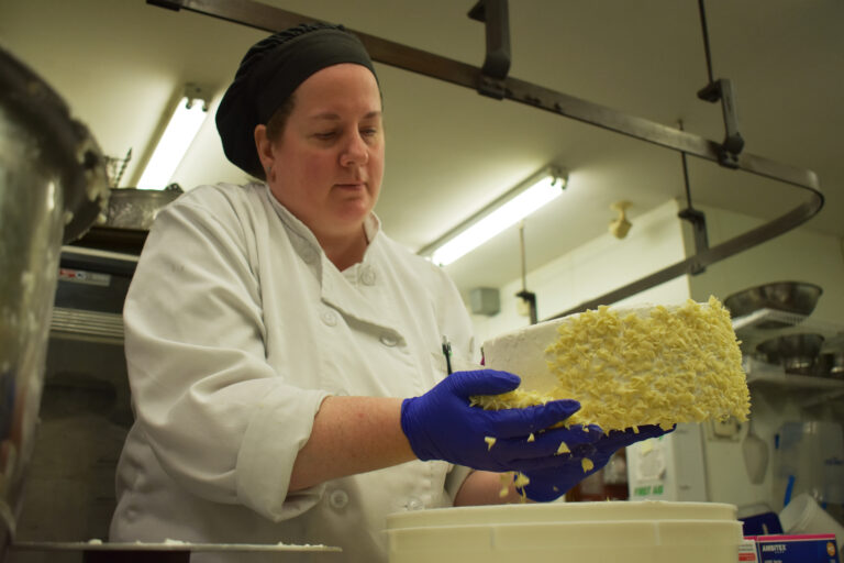 Baker decorates a white cake