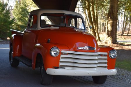 Orange classic Chevy parked beneath Ridgecrest portico